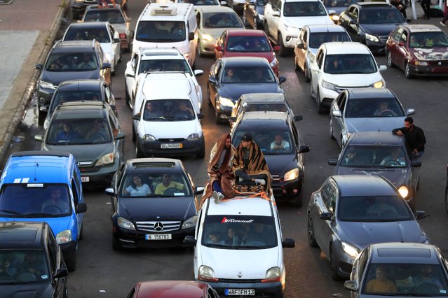 Lebanese citizens who fled the southern villages amid ongoing Israeli airstrikes Monday, sit on their cars at a highway that links to Beirut city, in the southern port city of Sidon, Lebanon, Tuesday, September 24, 2024. (Photo by Mohammed Zaatari/AP Photo)