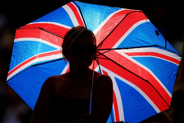 A fan on Andy Murray shelters from the sun under a union jack umbrella at the Wimbledon Lawn Tennis Championships, on Jule 2, 2014. (Photo by Al Bello/Getty Images)