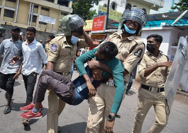 Policemen carry an injured protestor during a protest against “Agnipath scheme” for recruiting personnel for armed forces, in Secunderabad in the southern state of Andhra Pradesh, India, June 17, 2022. (Photo by Reuters/Stringer)