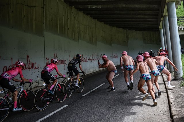 Scantily clad spectators run alongside riders in the ascent of the Col du Tourmalet during the 6th stage of the 110th edition of the Tour de France cycling race, 145 km between Tarbes and Cauterets-Cambasque, in the Pyrenees mountains in southwestern France, on July 6, 2023. (Photo by Anne-Christine Poujoulat/AFP Photo)