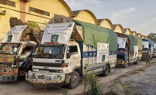 In this photo released by Pakistan's National Disaster Management Authority, a convoy of trucks carrying relief good including tents, blankets and emergency medicines for Afghanistan's earthquake hit areas, prepare to leave for Afghanistan at a warehouse in Islamabad, Pakistan, Thursday, June 23, 2022. (Photo by National Disaster Management Authority via AP Photo)