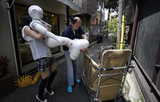 Tomomi Ota (L) and her father Norio load humanoid robot Pepper into a cart in Tokyo, Japan, 26 June 2016. (Photo by Franck Robichon/EPA)