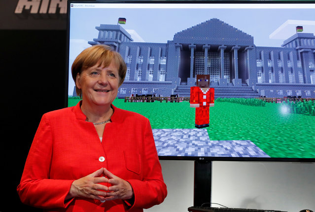 German Chancellor Angela Merkel stands next to a screen depicting a Minecraft rendition of her and the Reichstag building during the opening of the world's largest computer games fair Gamescom in Cologne, Germany, August 22, 2017. (Photo by Wolfgang Rattay/Reuters)