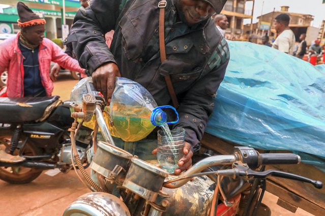 A man pours fuel into his motorcycle near a fuel station in Yaounde, on July 19, 2022. For almost two weeks now, gasoline and diesel have been in short supply in the main cities of Cameroon. (Photo by Daniel Beloumou Olomo/AFP Photo)