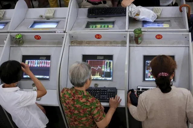 Investors look at computer screens showing stock information at a brokerage in Shanghai, China, August 24, 2015. Chinese stocks dived more than 8 percent on Monday morning, with the Shanghai index giving up all its gains for the year on investor disappointment that Beijing held back expected policy support at the weekend after markets shed 11 percent last week. (Photo by Aly Song/Reuters)