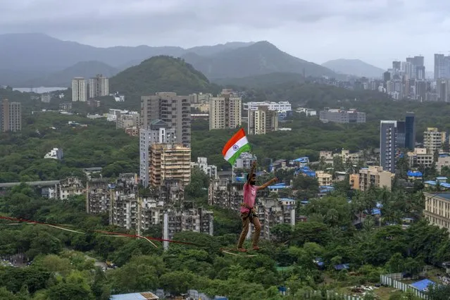 Indian highliner Harshdeep Pawar walks holding the Indian flag on Independence Day in Mumbai, India, Monday, August 15, 2022. The country is marking the 75th anniversary of its independence from British rule. (Photo by Rafiq Maqbool/AP Photo)