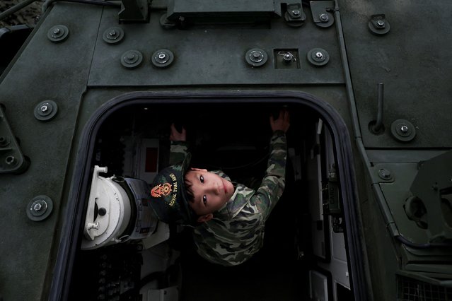 A boy looks on as he plays in an army vehicle during Children's Day celebration at a military facility in Bangkok, Thailand, on January 11, 2025. (Photo by Chalinee Thirasupa/Reuters)
