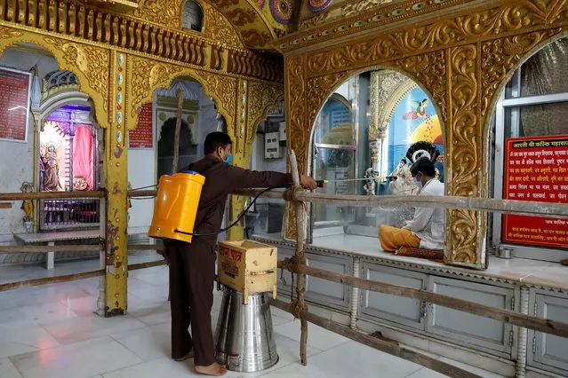A man disinfects a temple after the opening of most of the religious places after India eases lockdown restrictions that were imposed to slow the spread of the coronavirus disease (COVID-19), in New Delhi, India, June 8, 2020. (Photo by Anushree Fadnavis/Reuters)