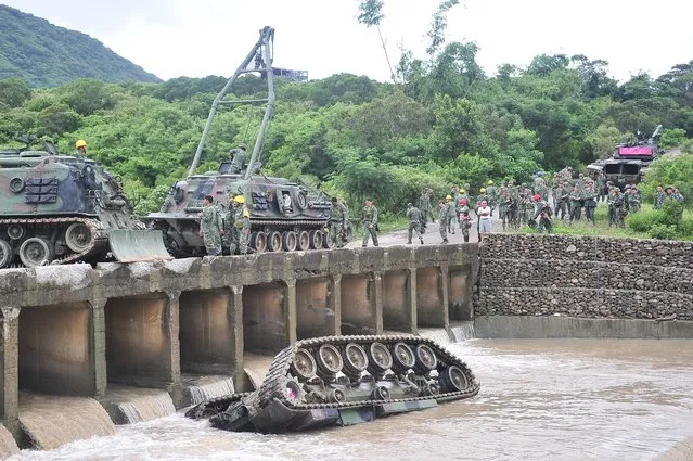 A CM11 armoured vehicle lies upside down in a river killing four of the five soldiers inside in southern Pingtung on August 16, 2016. The soldiers were killed when a tank slipped and plunged into a river during heavy rains following an annual firing drill in southern Taiwan, officials said on August 16. (Photo by AFP Photo/Stringer)