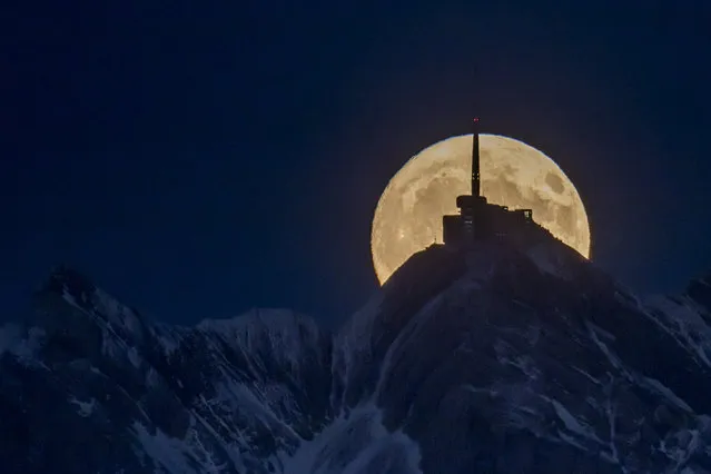 The moon rises in front of the mountain Saentis with a height of 2,502 meters, seen from a hill near the village of Ebnat-Kappel, in Switzerland, 03 November 2017. (Photo by Christian Merz/EPA/EFE)