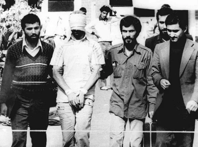 In this November 9, 1979, file photo, one of the hostages being held at the U.S. Embassy in Tehran is displayed blindfolded and with his hands bound to the crowd outside the embassy. (Photo by AP Photo)