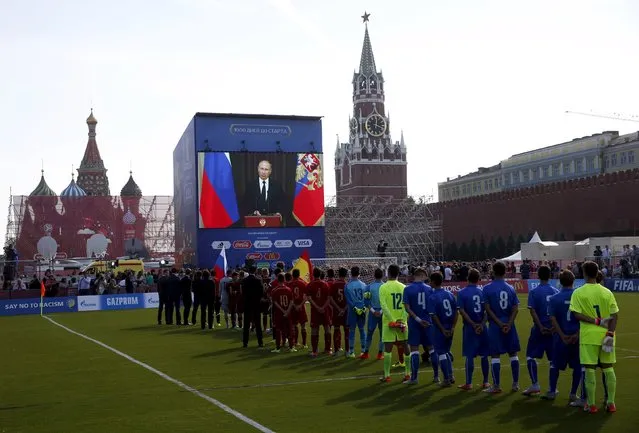 Officials, participants of a soccer exhibition under-16 tournament and spectators listen to Russia's President Vladimir Putin delivering a speech via a video link from Sochi, during a ceremony marking 1,000 days until the beginning of the 2018 FIFA World Cup in Red Square in central Moscow, Russia, September 18, 2015. (Photo by Maxim Zmeyev/Reuters)