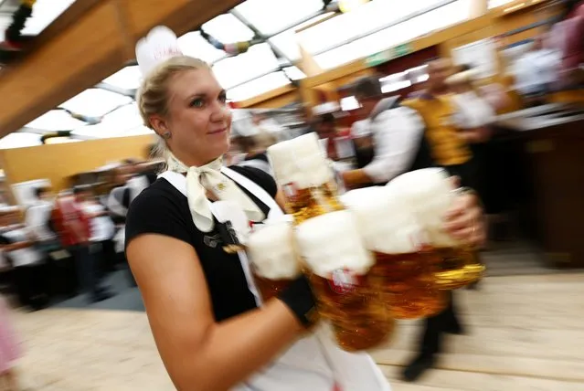 A waitress carries beer in a tent during the 182nd Oktoberfest in Munich, Germany, September 19, 2015. (Photo by Michaela Rehle/Reuters)