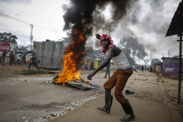 A supporter of the opposition coalition the National Super Alliance (NASA) and its presidential candidate Raila Odinga prepares to throw a stone with a slingshot as he and others face off with police during their protest in Kibera slum, Nairobi, Kenya, 20 November 2017, immediately after the top court delivered its verdict upholding President Uhuru Kenyatta's victory in October 26 Presidential election re-run. An EPA photojournalist witnessed at least two people shot dead allegedly by police during their clash. (Photo by Dai Kurokawa/EPA/EFE)