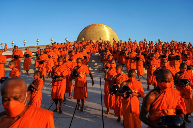 Thai Buddhist monks are walking in line to collect food during the mass morning alms-giving ceremony to mark the start of the new year at Wat Phra Dhammakaya Temple in Pathum Thani Province, Thailand, on January 1, 2024. (Photo by Anusak Laowilas/NurPhoto/Rex Features/Shutterstock)