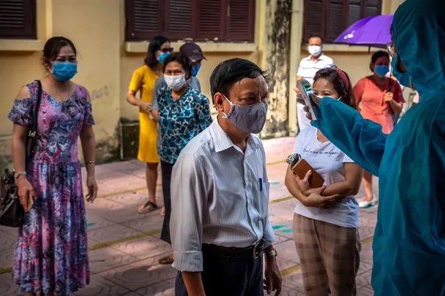 People who recently returned from Da Nang city wear face masks while queuing in safe distance to take the coronavirus disease (COVID-19) rapid test on July 31, 2020 in Hanoi, Vietnam. As of July 31, community transmissions have spread from Da Nang city to five other cities including Hanoi & Ho Chi Minh City. With the 45 new cases, the largest number of domestic infections reported in one day in Vietnam ever since the first cases were detected in the country in February, the nation now has 509 Covid-19 patients. Of these, 369 have recovered and no deaths. (Photo by Getty Images/Stringer)