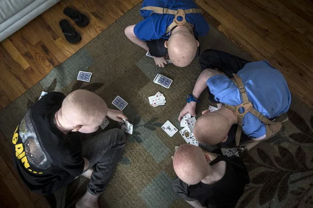 Children from Tanzania play cards in the living room in Staten Island. (Photo by Carlo Allegri/Reuters)