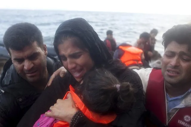 A Syrian refugee family embraces following their arrival on an overcrowded dinghy in rough sea on the Greek island of Lesbos, after crossing a part of the Aegean Sea from the Turkish coast, October 2, 2015. (Photo by Dimitris Michalakis/Reuters)