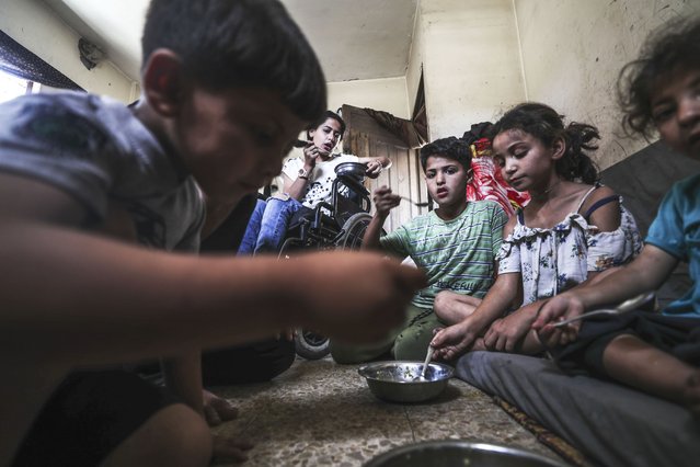 Palestinians, struggling with hunger due to Israeli embargo, wait in line to receive hot meals distributed by the charity organizations as Israeli attacks continue, in Jabalia Refugee Camp in Gaza City, Gaza on May 26, 2025. (Photo by Mahmoud Issa/Anadolu via Getty Images)