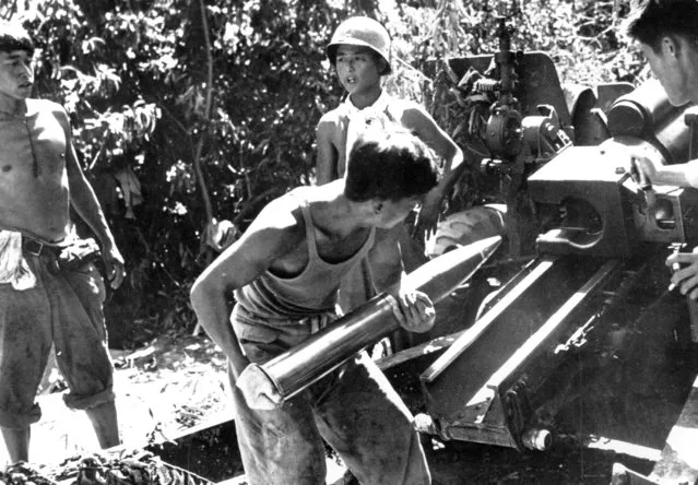 South Korean gunners load their 105mm Howitzer near the front during the Korean War as they fire in support of the First Korean Infantry Division on August 2, 1950. (Photo by AP Photo)