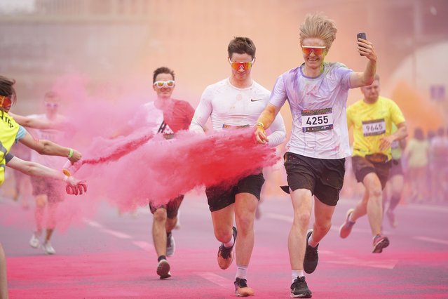 Participants get covered with colored powder during The Color Run in Moscow, Russia, Sunday, June 8, 2025. (Photo by Pavel Bednyakov/AP Photo)