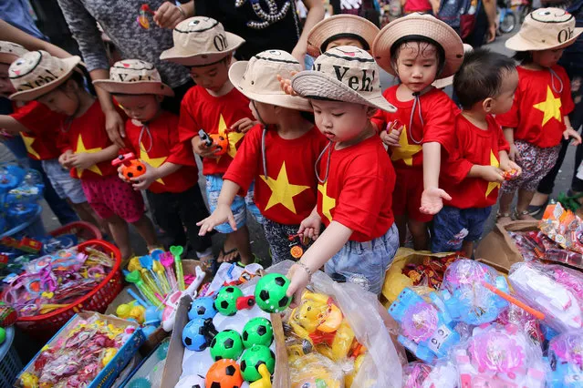 Vietnamese children shop for toys at a street in Hanoi, Vietnam 23 September 2015. Vietnamese people are going to celebrate the Mid-Autumn Festival, one of the most important traditional events during the year. Its a children's festival featuring moon cakes, paper lanterns, dragon dances. (Photo by Luong Thai Linh/EPA)
