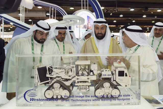 Kuwait's Oil Minister Ali Al-Omair (C) visits a booth at the opening of the exhibition of the 2nd Kuwait Oil and Gas Show and Conference in Mishref, Kuwait, October 12, 2015. Ali Al-Omair said on Monday there were currently no calls from within OPEC to change the oil-producing group's output ceiling and that a market exit by high-cost producers could help buoy oil prices in 2016. (Photo by Stephanie McGehee/Reuters)