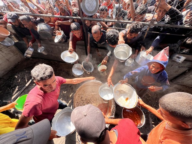 A charity organization distributes hot meals to Palestinians in Gaza City, Gaza on June 11, 2025. The food crisis continues in the Gaza Strip under Israeli attacks due to the closed border gates. (Photo by Abed Rahim Khatib/Anadolu via Getty Images)
