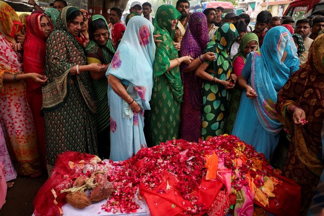 Friends and family members offer flower petals to the coffin of Chetnaba Chavda, who died in the Air India Boeing 787-8 Dreamliner plane crash, in Ahmedabad, India on June 18, 2025. (Photo by Amit Dave/Reuters)