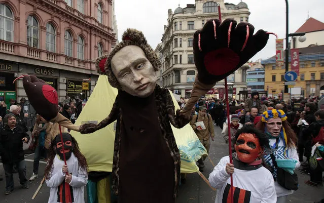 People, one wearing a mask depicting Russian President Vladimir Putin, march through the city center to commemorate the 25th anniversary of the Velvet Revolution in Prague November 17, 2014. (Photo by David W. Cerny/Reuters)