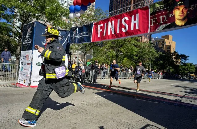 Robert Sutherland, of Farmingdale, N.Y., a member of the East Farmingdale Fire Department, crosses the finish line during the Stephen Siller Tunnel to Towers memorial event in New York, Sunday, September 25 2016. The run honors New York firefighter Stephen Siller who made his way from his Brooklyn firehouse through the Hugh Carey Tunnel, then known as the Brooklyn Battery Tunnel, to the World Trade Center, where he died in the collapse of the towers on Sept. 11, 2001. (Photo by Craig Ruttle/AP Photo)
