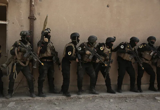 In this Saturday, August 13, 2016 file photo, soldiers from the 1st Battalion of the Iraqi Special Operations Forces are stacked against a building during a training exercise to prepare for the operation to re-take Mosul from Islamic State militants, in Baghdad, Iraq. The disparate groups that make up Iraq's security forces are converging on the city of Mosul, lining up for a battle on the historic plains of northern Iraq that is likely to be decisive in the war against the Islamic State group. (Photo by Maya Alleruzzo/AP Photo)