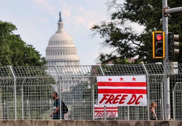 A banner depicting the Washington, D.C., flag with a text reading “Free DC” hangs from an overpass with a view of the U.S. Capitol after U.S. President Donald Trump announced federal take over of the Metropolitan Police Department under the Home Rule Act to assist in crime prevention in the nation's capital, in Washington, D.C., U.S., August 12, 2025. (Photo by Jonathan Ernst/Reuters)