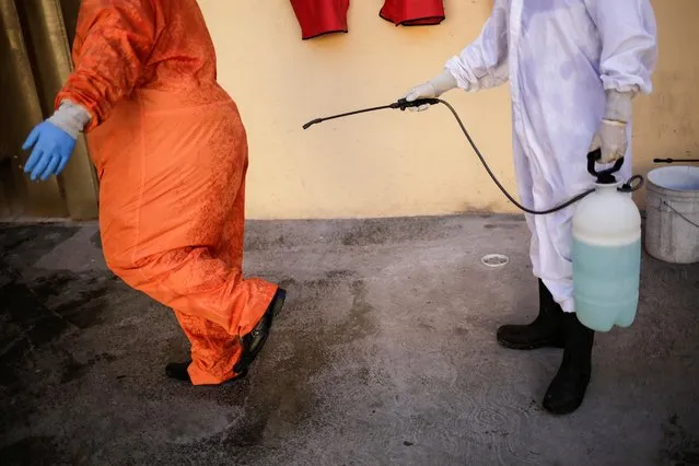 Employees of the Rios funeral home undergo sanitization at their facility after removing the body of a person who died of the coronavirus disease (COVID-19) from a home in Ciudad Juarez, Mexico on October 22, 2020. (Photo by Jose Luis Gonzalez/Reuters)