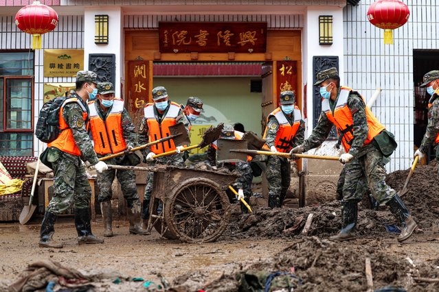 Members of the People's Armed Police Force Gansu Corps clean up mud in Xinglongshan Village, Yuzhong County of northwest China's Gansu Province, August 10, 2025. The People's Armed Police Force (PAPF) Gansu Corps mobilized over 400 officers and soldiers on Sunday, deploying them to several villages in Yuzhong County, including Xinglongshan, Maliantan, Xiaokangying, and Jiuzhuanggou. The forces will conduct disaster relief work, which includes searching for missing individuals, roadway clearing, transferring materials, and disinfecting affected areas. (Photo by Xinhua News Agency/Rex Features/Shutterstock)