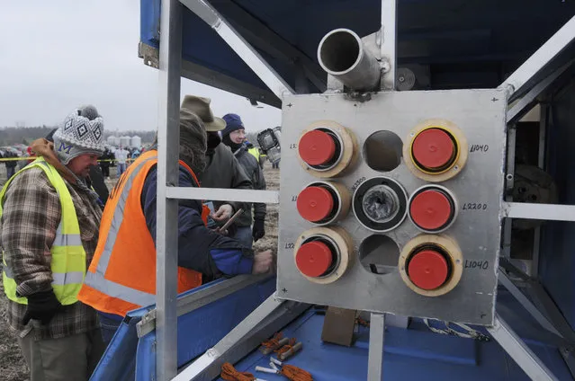 Members of the Michiana Rocketry prep a 10-foot, 450 pound porta-potty, mounted on rocket motors for launching, Saturday, December 6, 2014, from a field in Three Oaks, Mich. (Photo by Don Campbell/AP Photo/The Herald-Palladium)