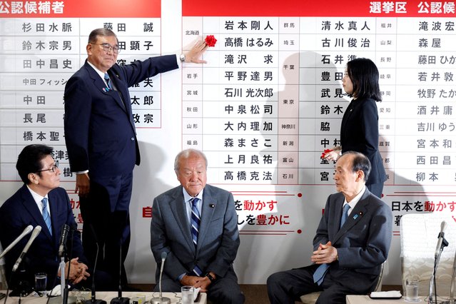 Shigeru Ishiba, Japanese Prime Minister and president of the ruling Liberal Democratic Party (LDP), places a red paper rose on the name of an elected candidate at the LDP headquarters, on the day of Upper House election, in Tokyo, Japan on July 20, 2025. (Photo by Franck Robichon/Pool vta Reuters)