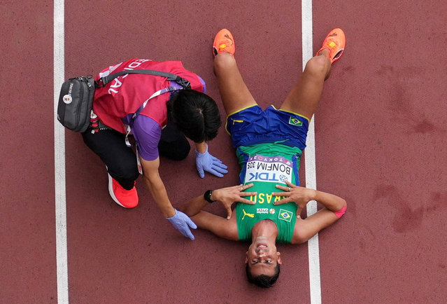 Brazil's Caio Bonfim reacts as a medic looks on after crossing the line to win the silver medal in the Men's 35km Race Walk Final on September 13, 2025. (Photo by Fabrizio Bensch/Reuters)
