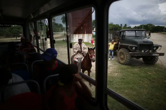 People being evacuated in a bus talk to a man riding a horse ahead of the arrival of Hurricane Matthew in Secilia, Cuba, October 3, 2016. (Photo by Alexandre Meneghini/Reuters)