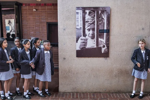 South African school children pause next to a portrait of the late South African anti-apartheid campaigner Winnie Madikizela-Mandela, ex-wife of African National Congress (ANC) leader Nelson Mandela, at her house on April 3, 2018 in Soweto. South Africa's President paid tribute to anti-apartheid activist Winnie Mandela, who died on April 2, saying that Nelson Mandela's former wife was a “voice of defiance” against white-minority rule. (Photo by Marco Longari/AFP Photo)