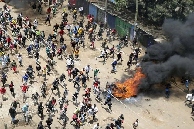 Protesters run towards riot police officers during a mass rally called by the opposition leader Raila Odinga over the high cost of living in Kibera Slums, Nairobi, Monday, March 27, 2023.(Photo by Brian Inganga/AP Photo)