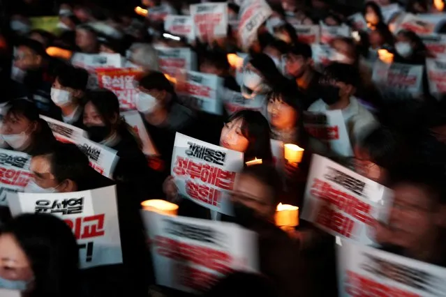 South Korean people hold placards as they attend a candlelight vigil that denounces a government plan to resolve a dispute over compensating people forced to work under Japan's 1910-1945 occupation of Korea, in Seoul, South Korea on March 6, 2023. (Photo by Kim Hong-Ji/Reuters)