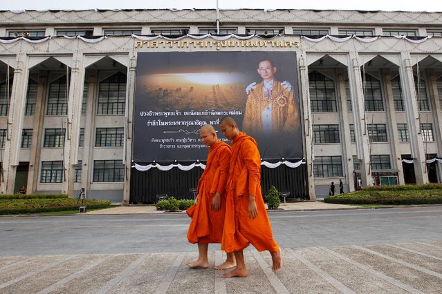Buddhist monks walk past a portrait of Thailand's late King Bhumibol Adulyadej outside Bangkok City Hall, Thailand, October 19, 2016. (Photo by Chaiwat Subprasom/Reuters)