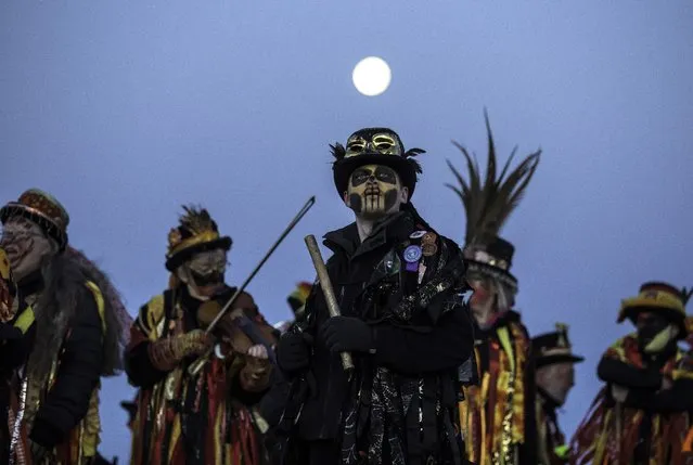 Members of the Powderkeg Morris Dancers climb down after dancing atop the Windgather Rocks at High Peak in Derbyshire before sunrise on May 1, 2018. The Powderkeg Morris dancers perform an annual dance atop the Windgather Rocks at sunrise, as part of an ancient Celtic festival celebrated on May Day or the beginning of summer. (Photo by Lindsey Parnaby/AFP Photo)