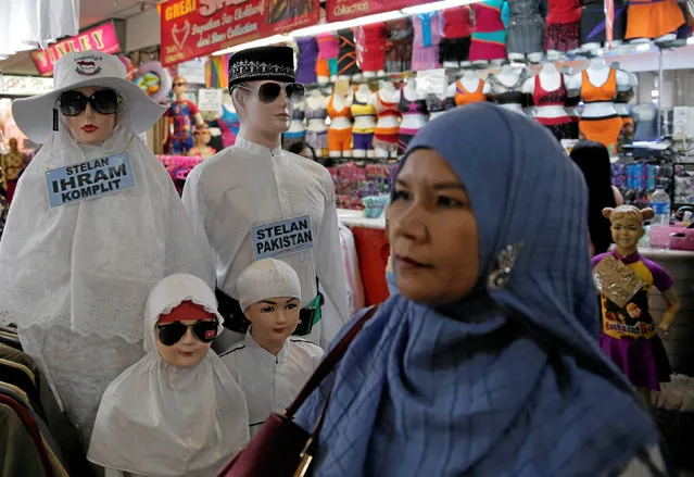 A woman walks past mannequins dressed in Muslim prayer garments at Tanah Abang cloth market in Jakarta, Indonesia, October 17, 2016. (Photo by Reuters/Beawiharta)