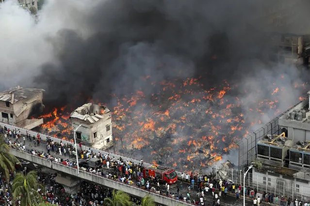 A fire rages at a popular market for cheaper clothes in Bangladesh's capital Dhaka, Bangladesh, Tuesday, April, 4, 2023. The fire broke out at Bangabazar Market in Dhaka on Tuesday, but no casualties were reported immediately. (Photo by Mahmud Hossain Opu/AP Photo)