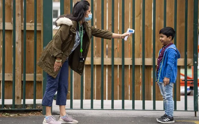 A child has his temperature checked by a teacher before entering Earlham Primary School, which is part of the Eko Trust on June 10, 2020 in London, England. As part of Covid-19 lockdown measures, Earlham Primary School is teaching smaller ‘bubbles’ of students, to help maintain social distancing measures. School staff have put into place many safety measures such as corridor signage for a one way system, regular supervised handwashing, temperature checks on arrival and enhanced cleaning regimes to keep pupils and staff as safe as possible. Bubbles of pupils are limited to six and each have their own well-ventilated space. The Government have announced it is set to drop plans for all English primary pupils to return to school before the end of the summer. (Photo by Justin Setterfield/Getty Images)