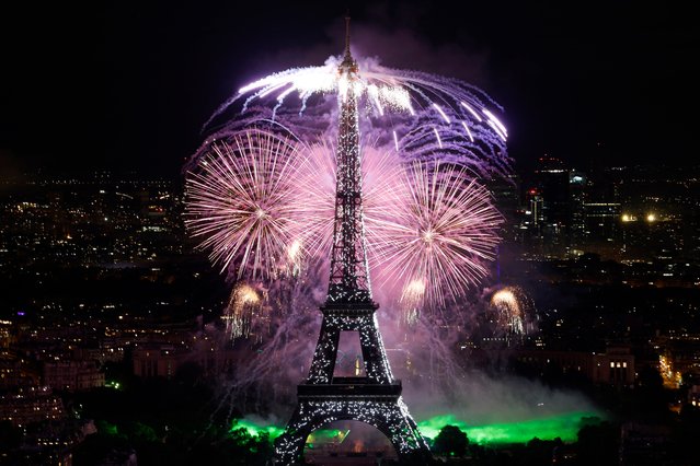 Fireworks explode next the Eiffel Tower as part of the annual Bastille Day celebrations in Paris, on July 14, 2024. (Photo by Olympia de Maismont/AFP Photo)