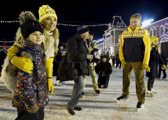 Ice dancer Tatyana Navka poses with a girl for a photo, with her husband Kremlin spokesman Dmitry Peskov (R) seen next to them, at an ice rink on its first day of operation in front of GUM department store in Moscow's Red Square, Russia November 28, 2015. (Photo by Sergei Karpukhin/Reuters)