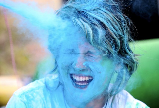 A woman reacts while sprayed with colour power during the annual Color Run Latvia, in Jurmala, Latvia, 25 August 2024. The annual event attracts thousands of participants who run through different color spray areas during a 5-kilometer distance run. The color run uses licensed food coloring that is natural and safe for the environment and people, according to Jurmala tourism information center. (Photo by Toms Kalnins/EPA/EFE)